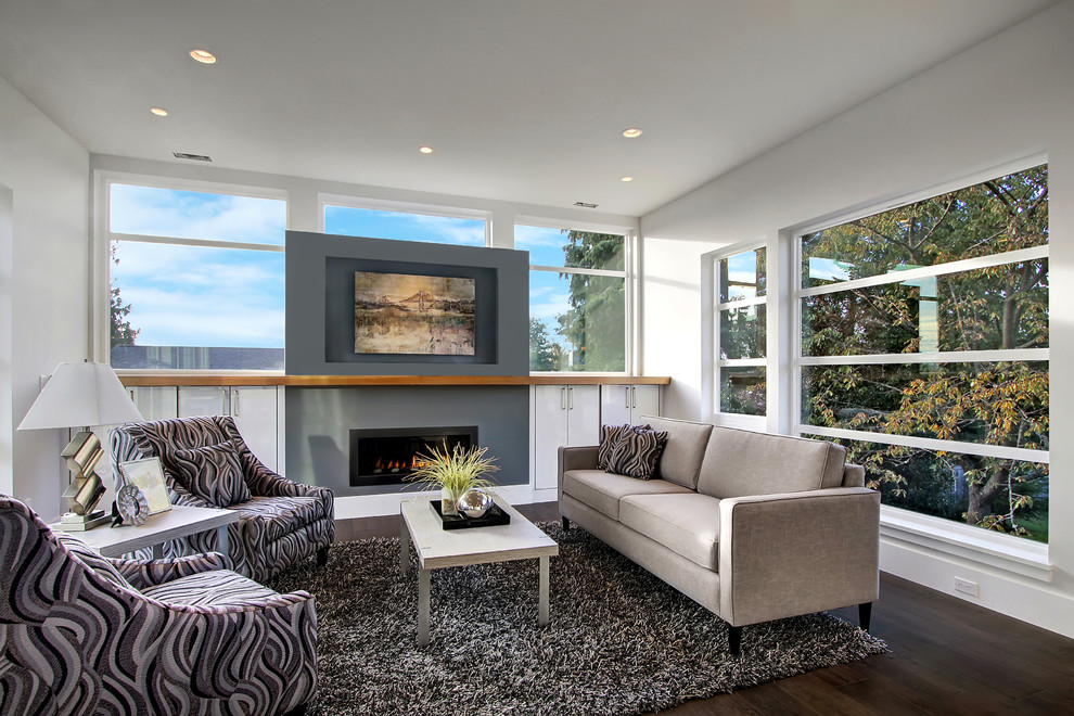 This is an example of a mid-sized contemporary open concept family room in Seattle with beige walls, dark hardwood floors, a ribbon fireplace and a concrete fireplace surround.