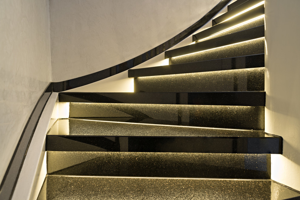 Mid-sized contemporary marble curved staircase in Cologne with marble risers and wood railing.