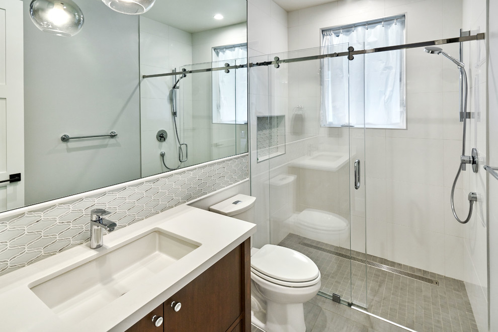 Photo of a mid-sized contemporary 3/4 bathroom in San Francisco with flat-panel cabinets, dark wood cabinets, an alcove shower, a two-piece toilet, white tile, grey walls, an undermount sink, engineered quartz benchtops, a sliding shower screen and white benchtops.