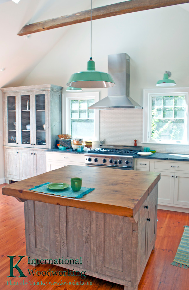 Country eat-in kitchen in Boston with distressed cabinets.