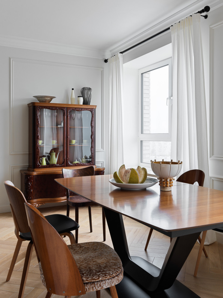 Esempio di una sala da pranzo aperta verso la cucina design di medie dimensioni con pareti bianche, parquet chiaro e pavimento beige