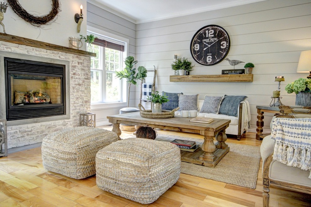 Inspiration for a mid-sized country open concept living room in Montreal with grey walls, light hardwood floors, a standard fireplace, a brick fireplace surround and beige floor.