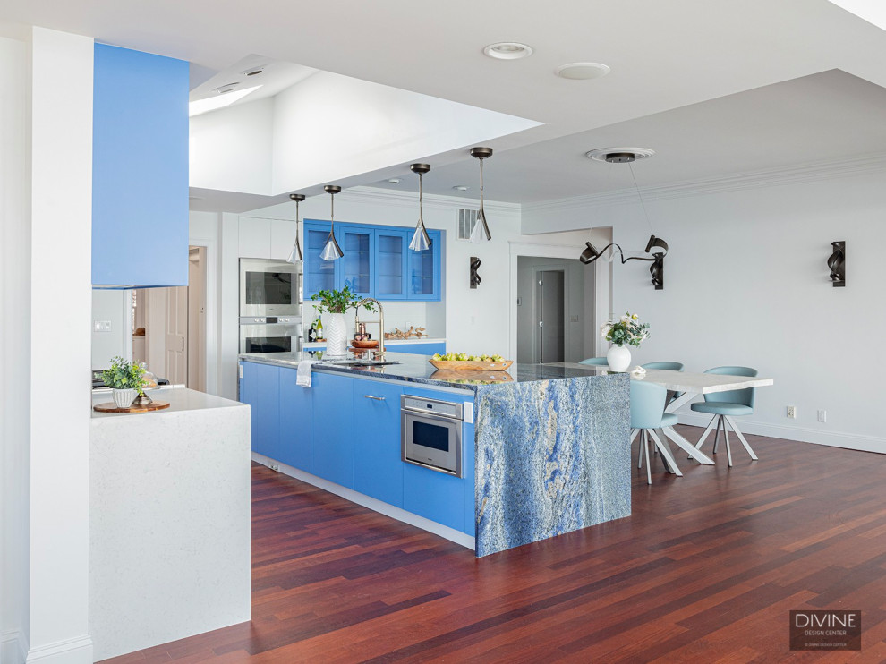 Exempel på ett mycket stort klassiskt blå blått kök, med luckor med glaspanel, blå skåp, marmorbänkskiva, rostfria vitvaror, mellanmörkt trägolv, en köksö och brunt golv