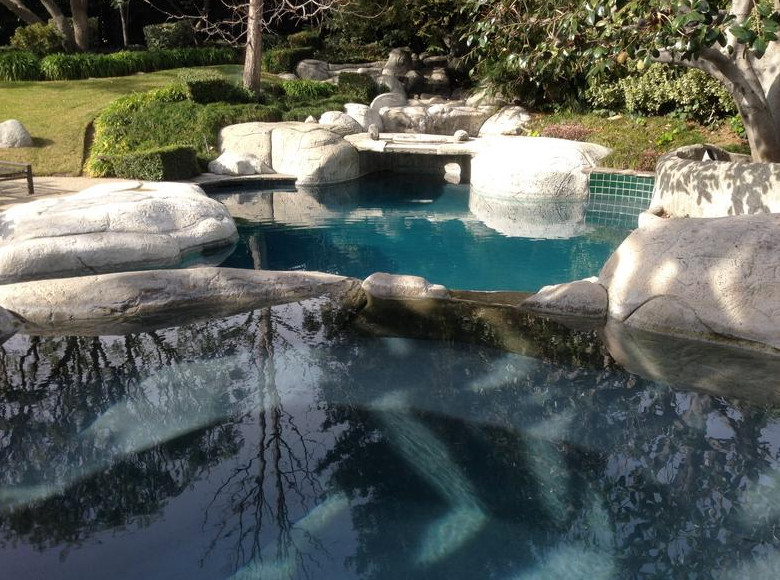 Example of a large mountain style backyard stone and custom-shaped natural pool fountain design in Los Angeles