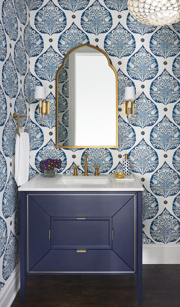 Small transitional powder room in Chicago with furniture-like cabinets, blue cabinets, blue walls, dark hardwood floors, an undermount sink, engineered quartz benchtops, brown floor, white benchtops, a freestanding vanity and wallpaper.