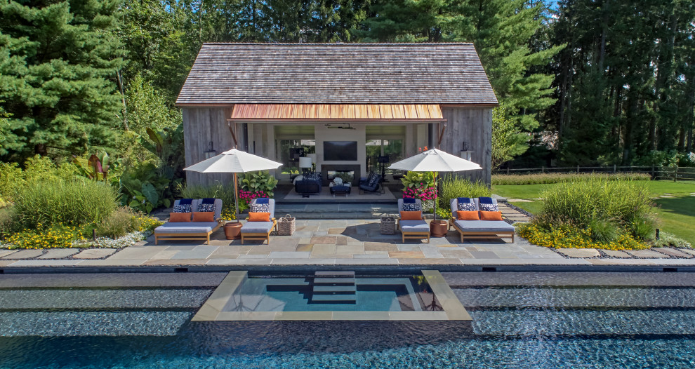 This is an example of a mid-sized country backyard rectangular pool in New York with a pool house.