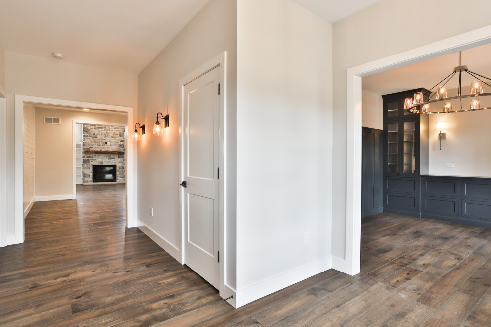 Geschlossenes, Mittelgroßes Landhaus Esszimmer mit weißer Wandfarbe, dunklem Holzboden, braunem Boden und vertäfelten Wänden in St. Louis