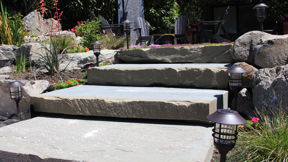 This is an example of a large transitional partial sun backyard stone formal garden in Seattle for summer.