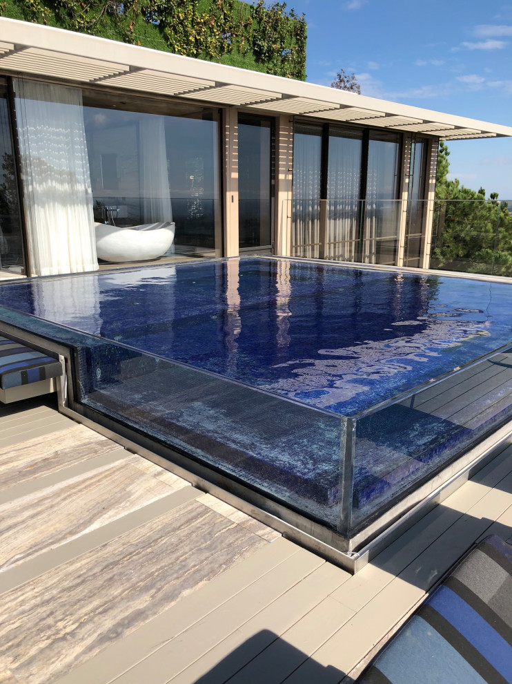 Photo of an expansive modern rooftop custom-shaped infinity pool in Los Angeles with with a pool and tile.