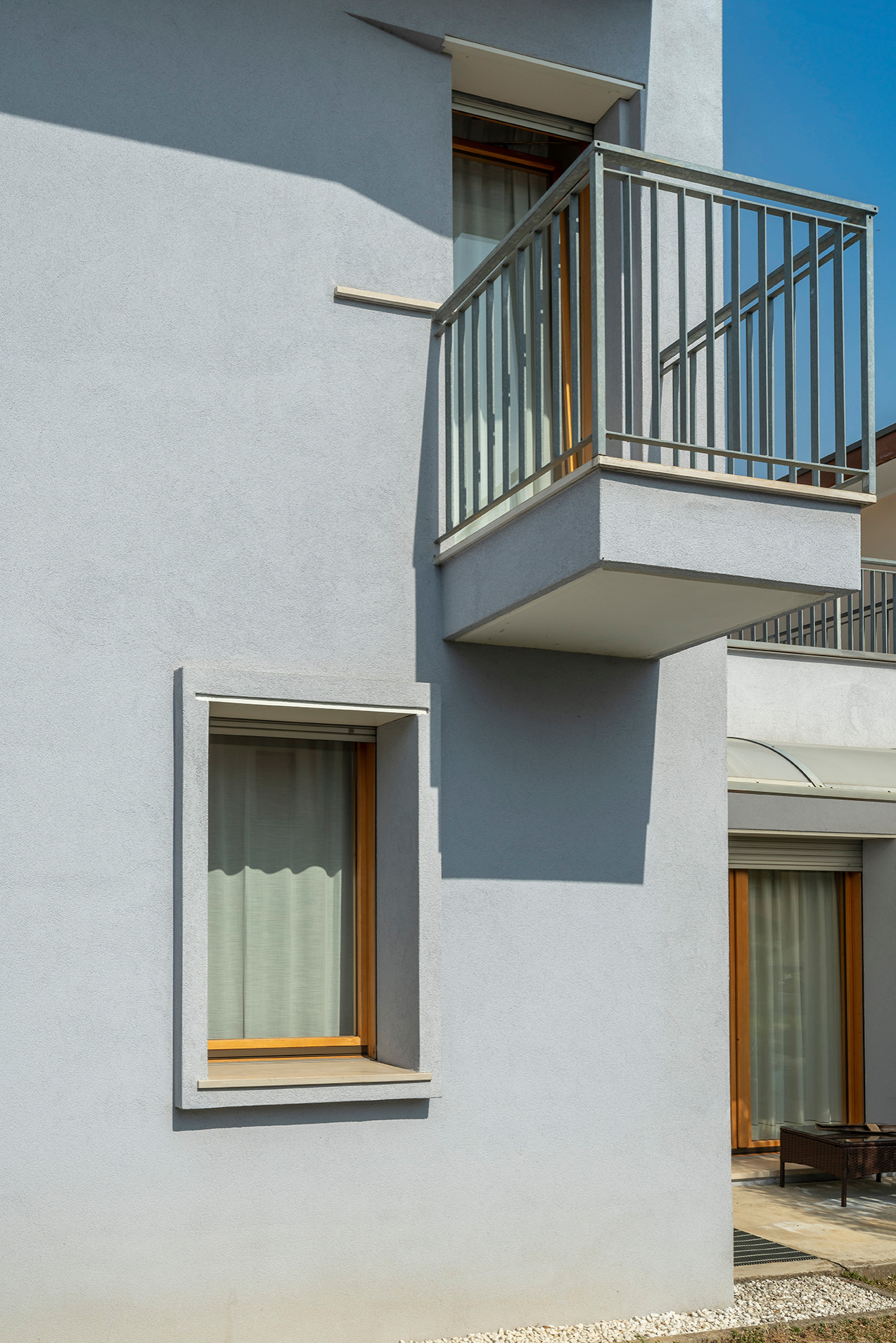 Immagine della villa grande bianca contemporanea a due piani con rivestimento in cemento, tetto piano e copertura in metallo o lamiera