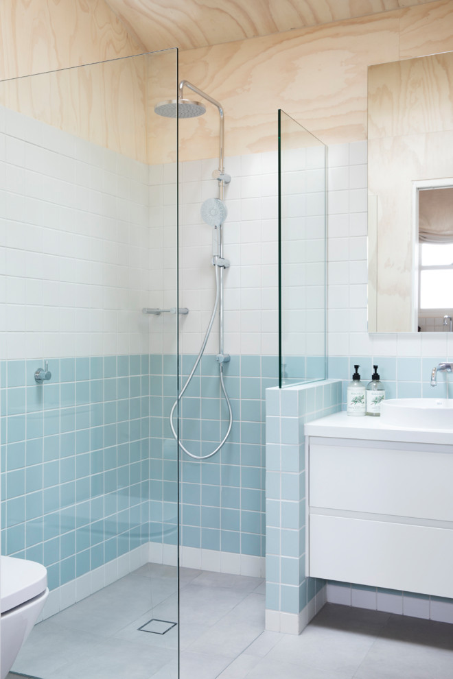 Пример оригинального дизайна: маленькая ванная комната в современном стиле с плоскими фасадами, белыми фасадами, открытым душем, раздельным унитазом, синей плиткой, керамогранитной плиткой, белыми стенами, полом из керамогранита, душевой кабиной, настольной раковиной, столешницей из ламината, серым полом, открытым душем, белой столешницей, тумбой под одну раковину, встроенной тумбой, деревянным потолком и деревянными стенами для на участке и в саду