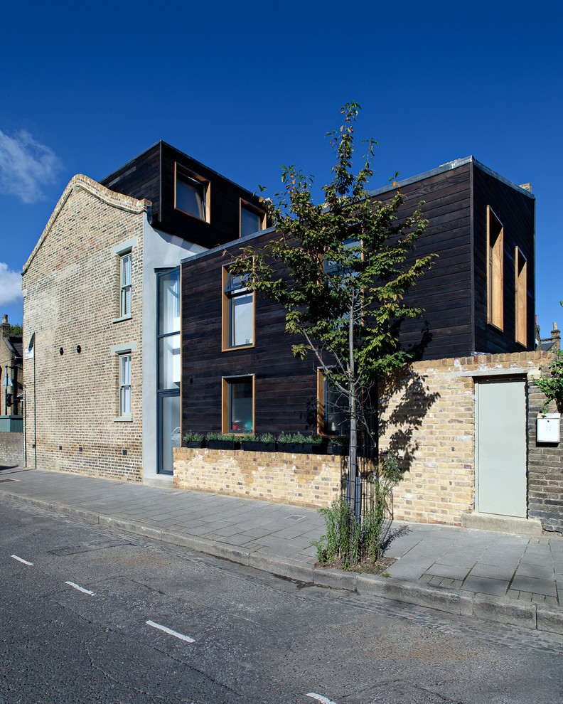 Contemporary house exterior in London with three floors and wood cladding.