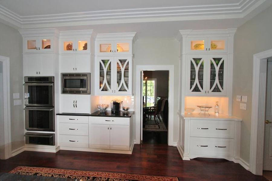 Example of a mid-sized transitional u-shaped dark wood floor enclosed kitchen design with flat-panel cabinets, white cabinets, white backsplash and stainless steel appliances