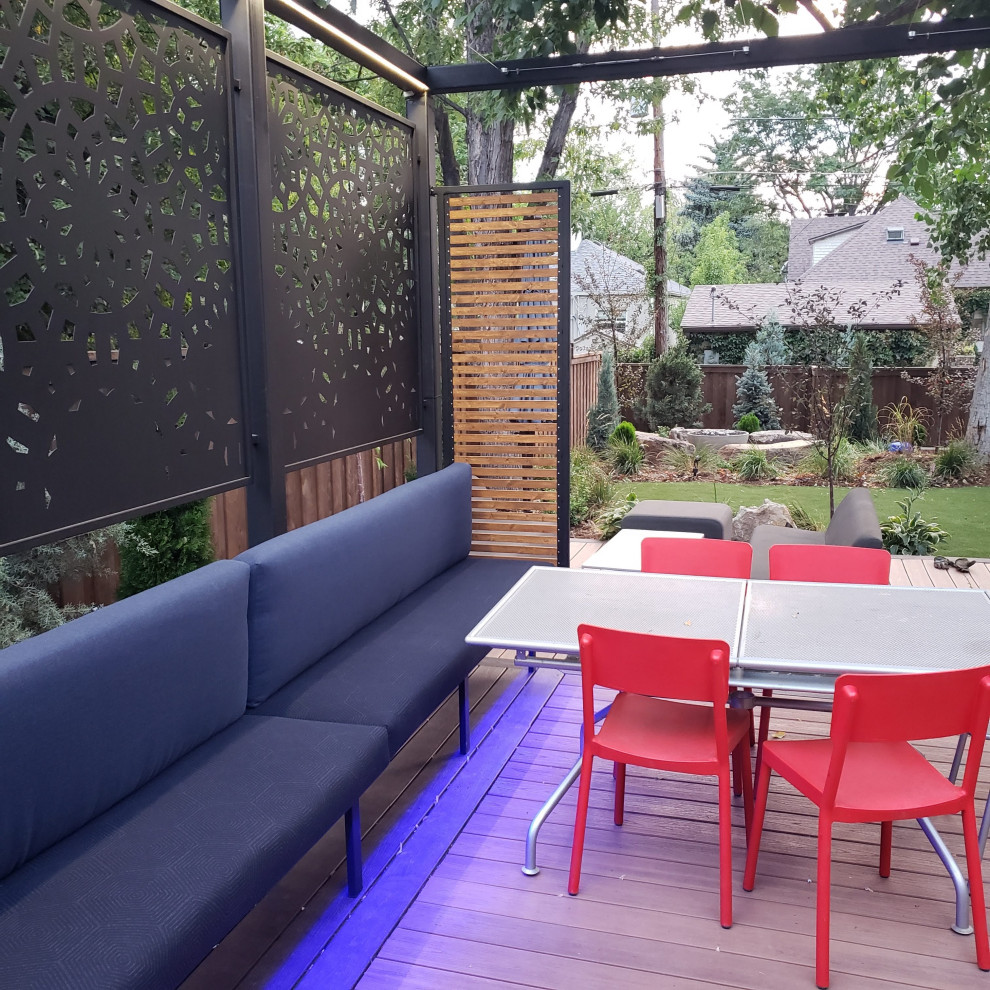 Ejemplo de terraza clásica renovada pequeña en patio trasero con toldo y barandilla de metal