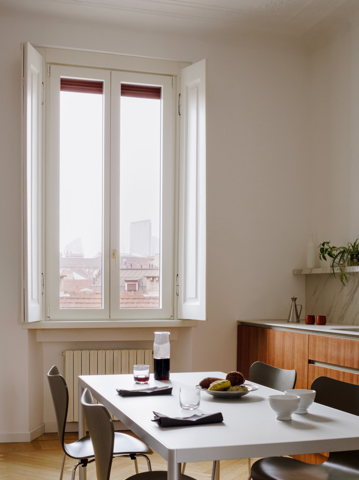 Einzeilige Moderne Wohnküche mit Unterbauwaschbecken, dunklen Holzschränken, Mineralwerkstoff-Arbeitsplatte und hellem Holzboden in Mailand