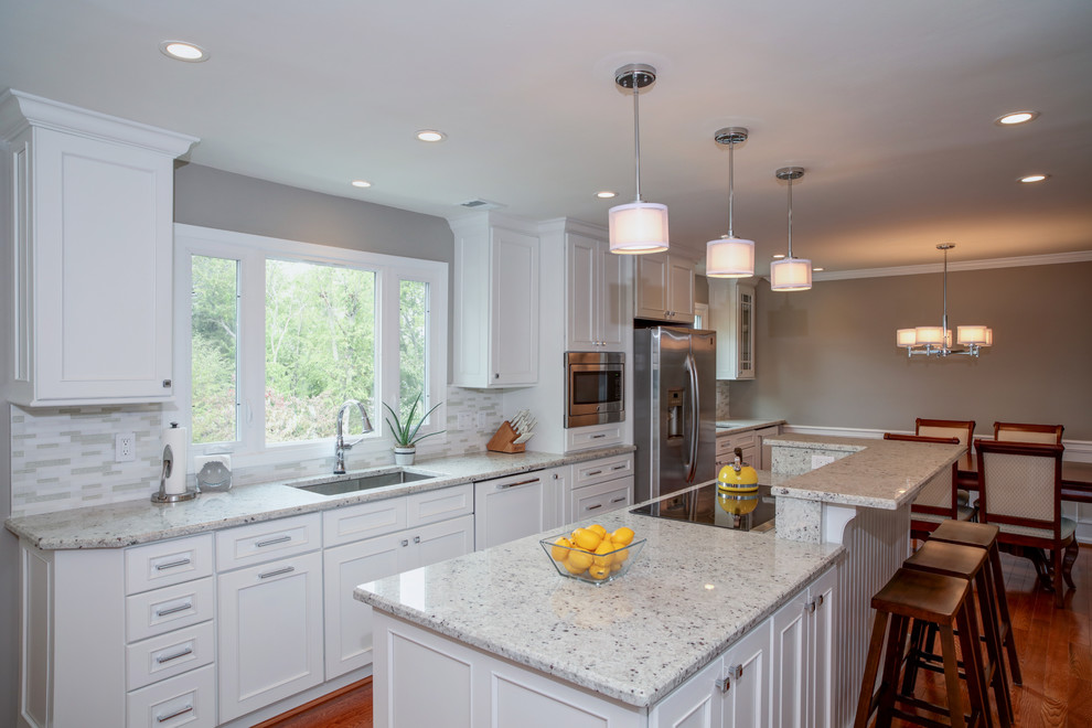 Eat-in kitchen - mid-sized transitional u-shaped medium tone wood floor eat-in kitchen idea in DC Metro with a single-bowl sink, beaded inset cabinets, white cabinets, quartz countertops, white backsplash, matchstick tile backsplash, stainless steel appliances and an island