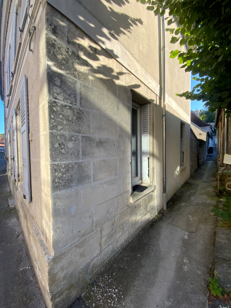 Esempio della facciata di una casa beige con rivestimento in pietra