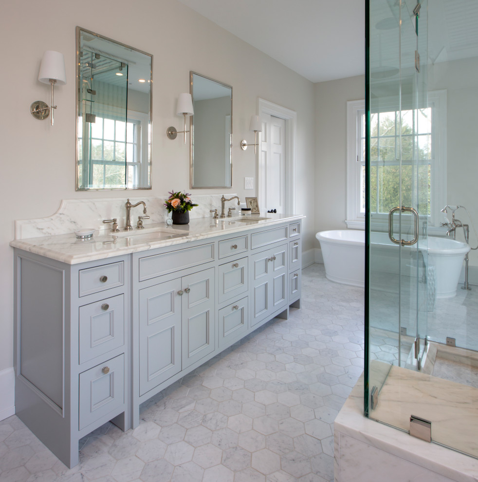 Пример оригинального дизайна: главная ванная комната среднего размера в классическом стиле с фасадами в стиле шейкер, серыми фасадами, отдельно стоящей ванной, раздельным унитазом, белыми стенами, мраморным полом, врезной раковиной, мраморной столешницей, серым полом, душем с распашными дверями, разноцветной столешницей, сиденьем для душа, тумбой под две раковины и встроенной тумбой