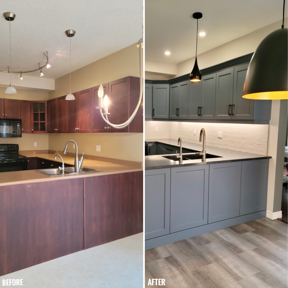 Eat-in kitchen - mid-sized transitional u-shaped vinyl floor eat-in kitchen idea with an undermount sink, recessed-panel cabinets, blue cabinets, quartzite countertops, white backsplash, porcelain backsplash, black appliances, a peninsula and black countertops