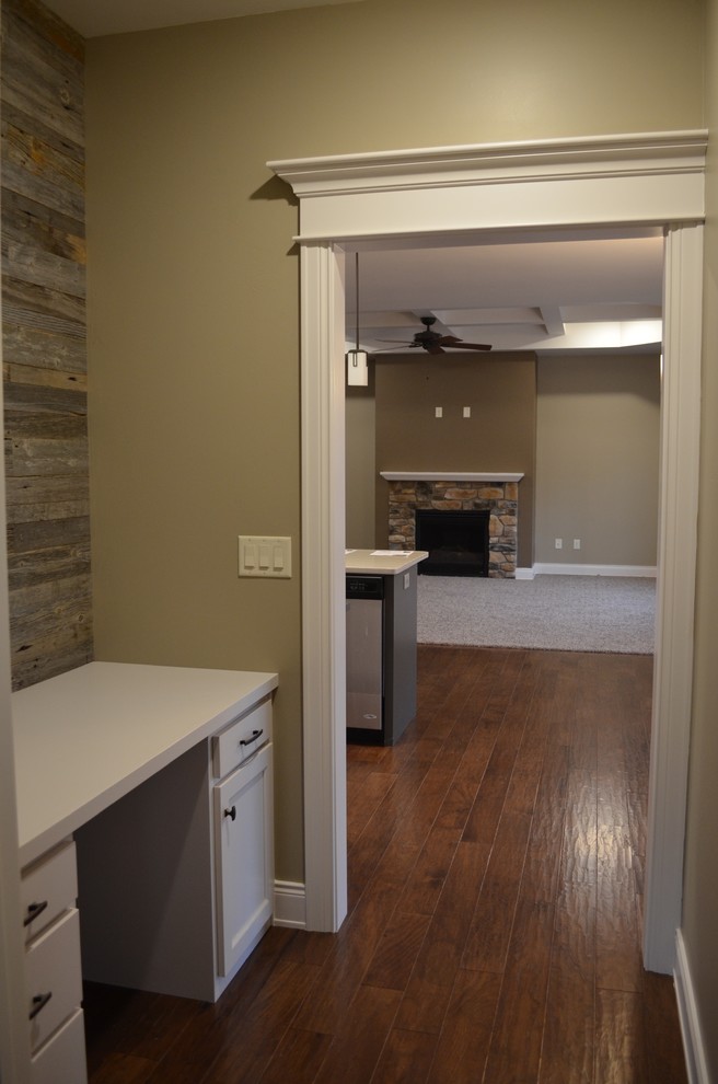Photo of a small eclectic hallway in Other with beige walls and dark hardwood floors.