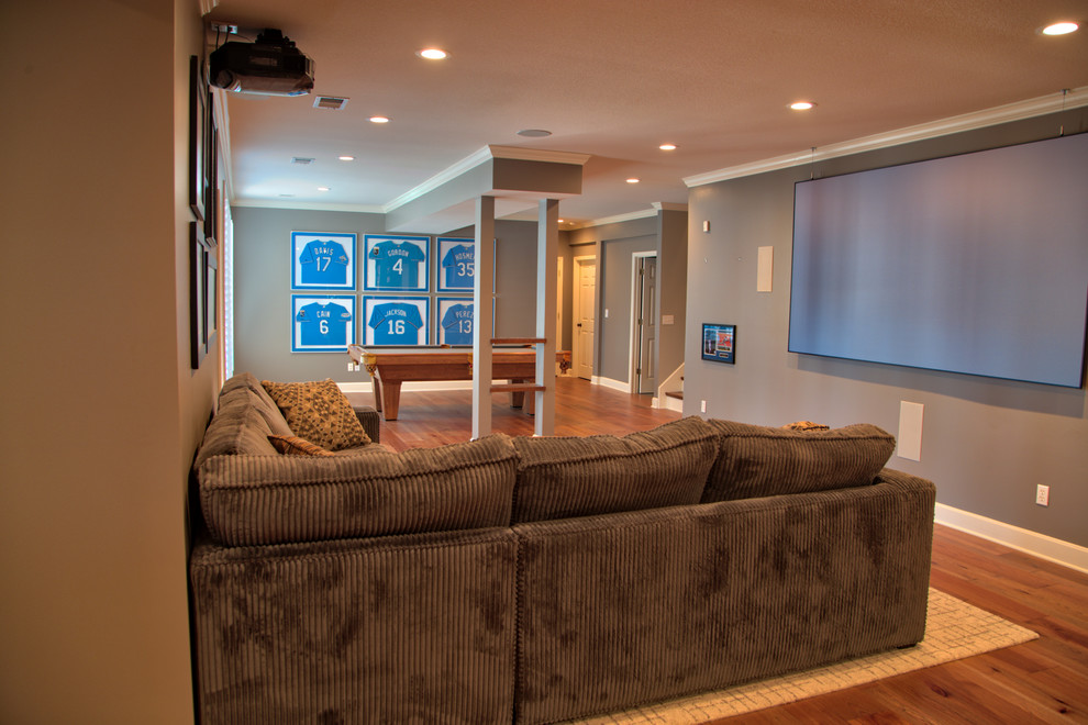 Photo of a large transitional basement in Kansas City with grey walls and medium hardwood floors.