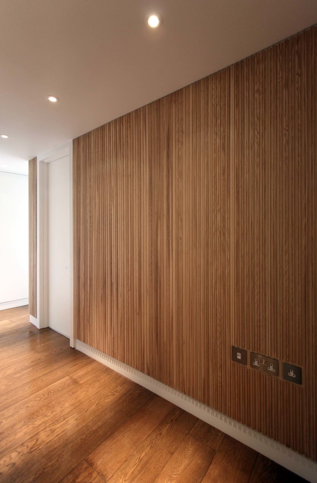 Inspiration for a mid-sized contemporary hallway in London with white walls and medium hardwood floors.