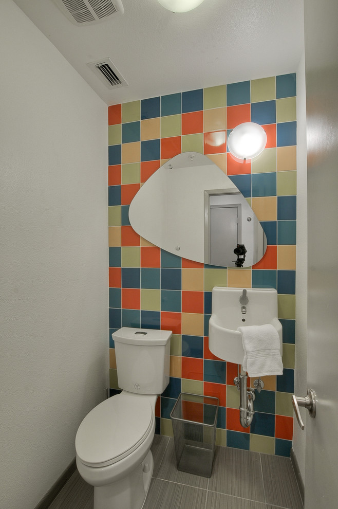 Small contemporary powder room in Dallas with ceramic tile, a wall-mount sink, multi-coloured tile, a two-piece toilet, porcelain floors and multi-coloured walls.