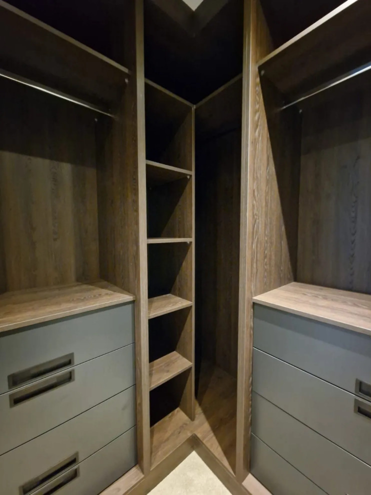 Small modern walk-in wardrobe in London with open cabinets, medium wood cabinets and feature lighting.