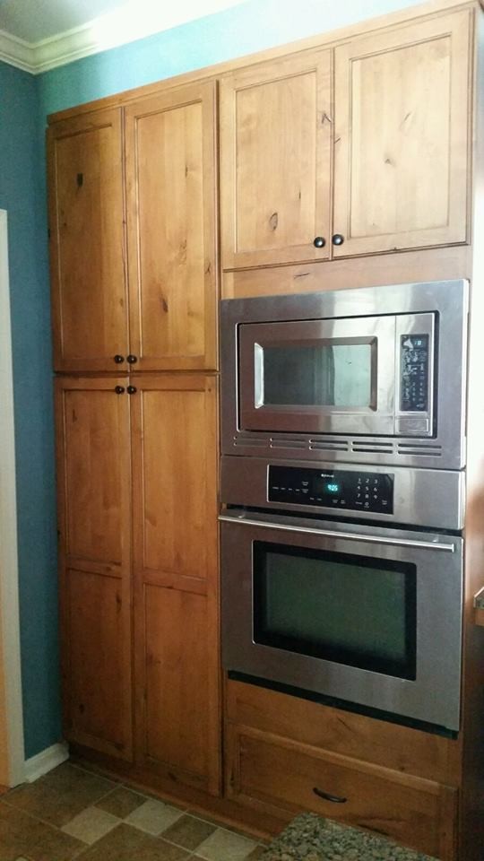 Inspiration for a mid-sized transitional l-shaped ceramic tile and brown floor eat-in kitchen remodel in Baltimore with a farmhouse sink, flat-panel cabinets, medium tone wood cabinets, granite countertops, gray backsplash, ceramic backsplash, paneled appliances and an island