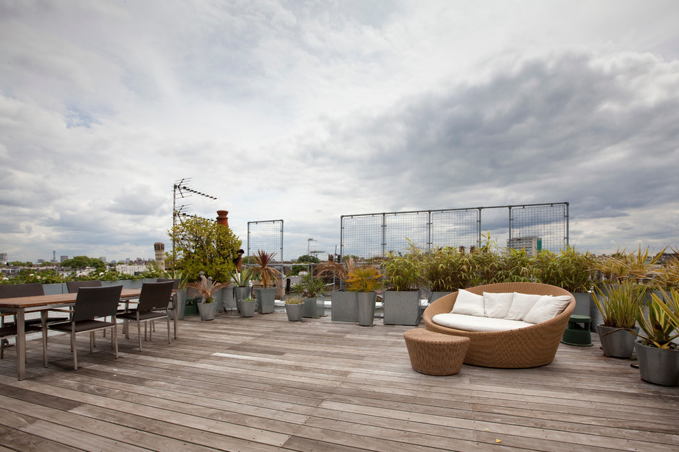 This is an example of an expansive contemporary rooftop deck in London with a container garden and no cover.
