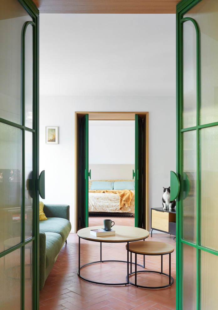 Mittelgroßes, Offenes Mediterranes Wohnzimmer ohne Kamin mit weißer Wandfarbe, Backsteinboden, Eck-TV und rotem Boden in Madrid
