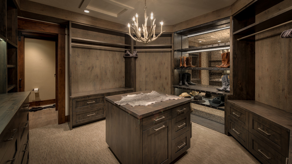 Mid-sized country gender-neutral walk-in wardrobe in Denver with recessed-panel cabinets, carpet, beige floor and medium wood cabinets.