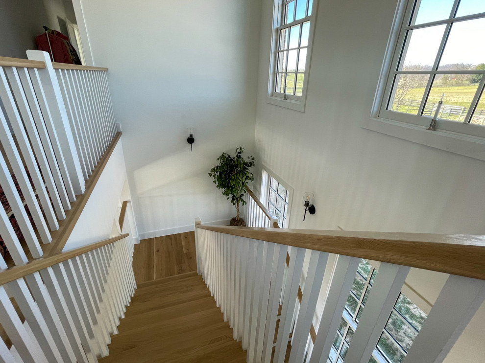 Mid-sized farmhouse wooden u-shaped wood railing and shiplap wall staircase photo in DC Metro with wooden risers