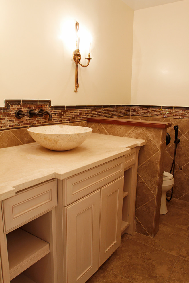Inspiration for a mid-sized traditional master bathroom in Orange County with a vessel sink, recessed-panel cabinets, white cabinets, marble benchtops, a two-piece toilet, beige tile, porcelain tile, beige walls and porcelain floors.