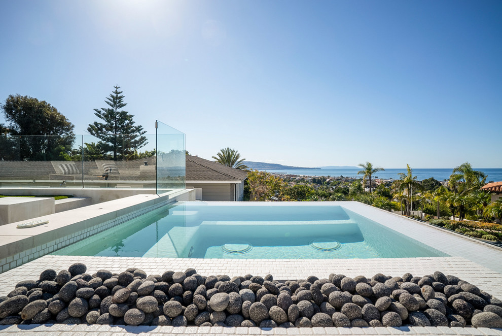 Inspiration for a large contemporary rooftop rectangular pool in Los Angeles with natural stone pavers.