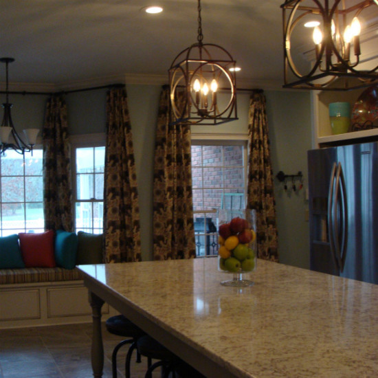 Example of a transitional ceramic tile kitchen design with an undermount sink, raised-panel cabinets, white cabinets, solid surface countertops, subway tile backsplash, stainless steel appliances and an island