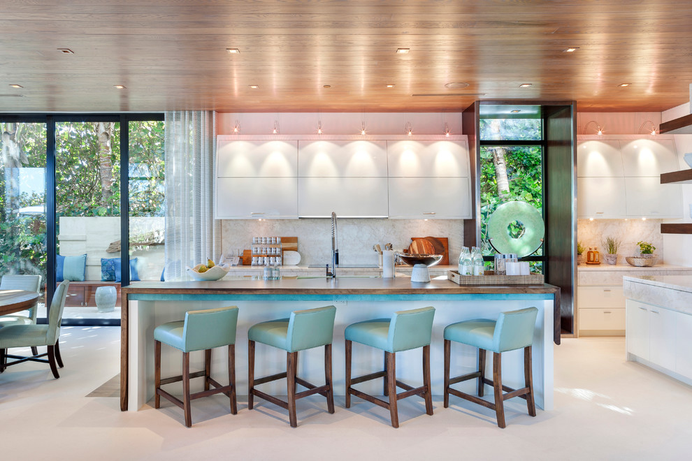 Contemporary eat-in kitchen in Miami with flat-panel cabinets, white cabinets, white splashback and with island.