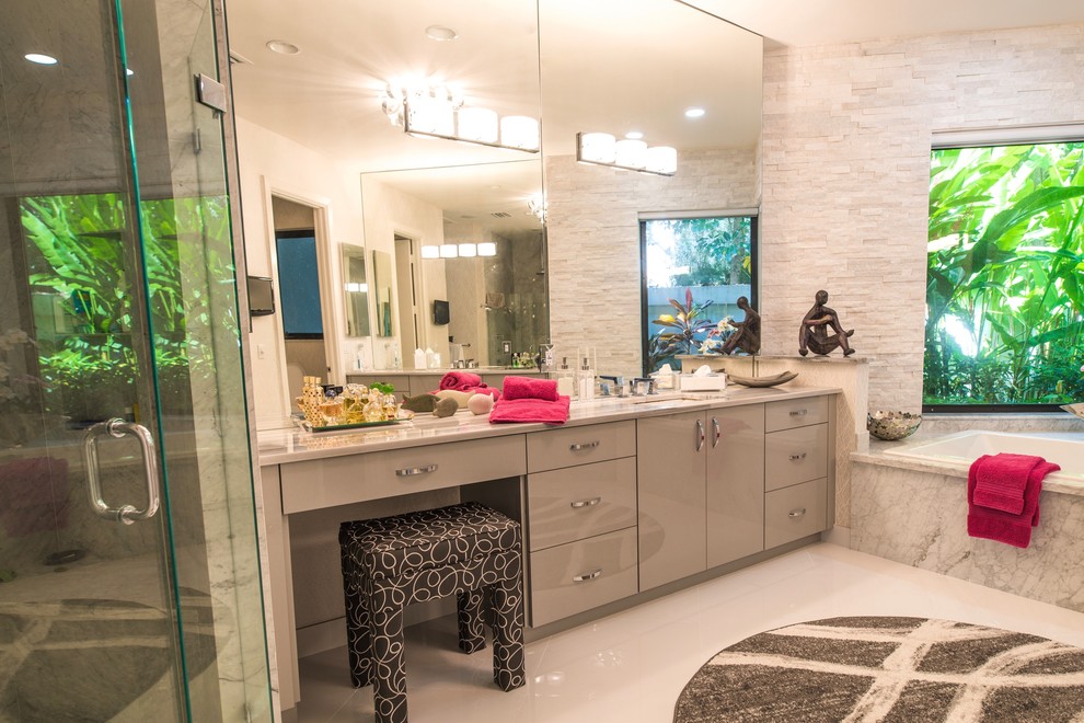 Design ideas for a large contemporary master bathroom in Miami with flat-panel cabinets, grey cabinets, a corner tub, a corner shower, a one-piece toilet, white tile, stone slab, grey walls, ceramic floors, an undermount sink and marble benchtops.