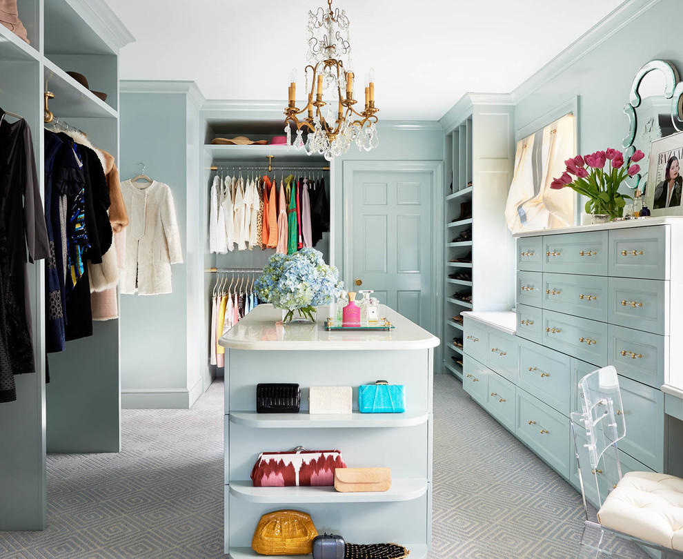 This is an example of a large traditional women's dressing room in Charlotte with recessed-panel cabinets, blue cabinets, carpet and grey floor.