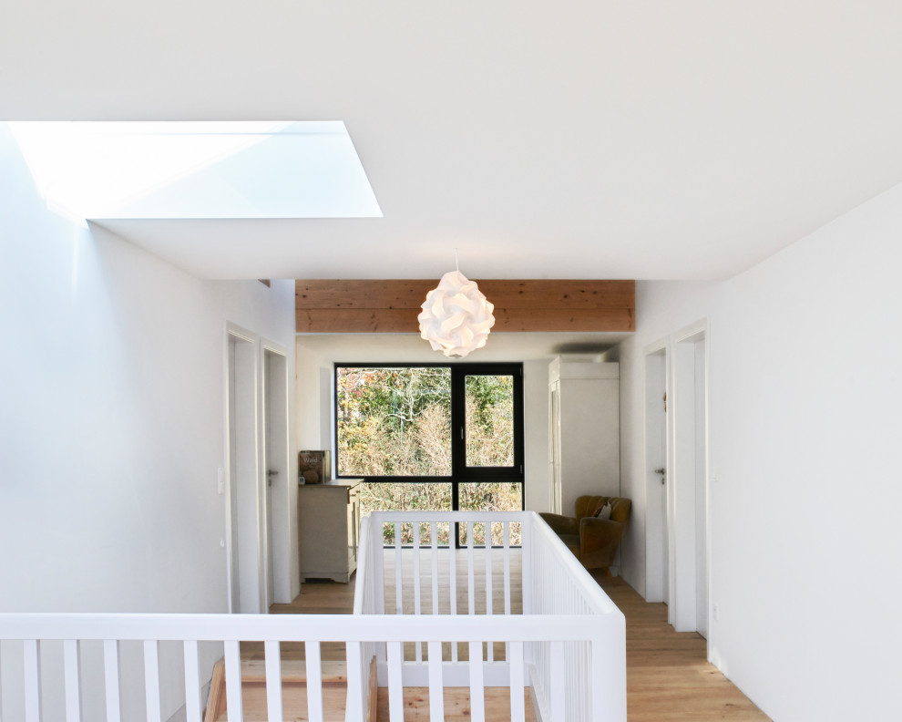 Großer Uriger Flur mit weißer Wandfarbe, hellem Holzboden und braunem Boden in Berlin