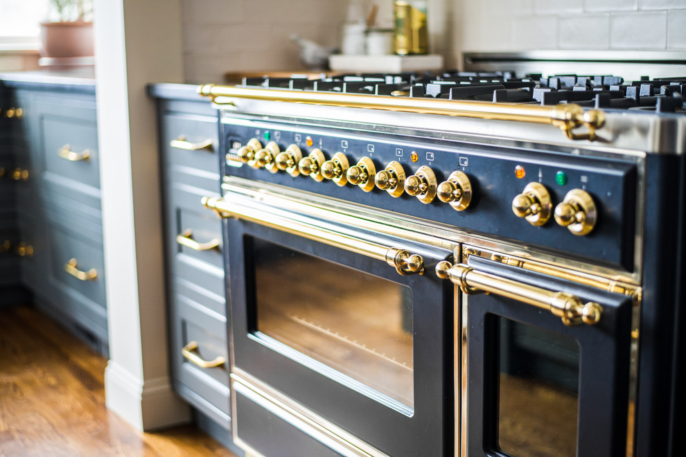 Transitional medium tone wood floor kitchen photo in Boston with an island