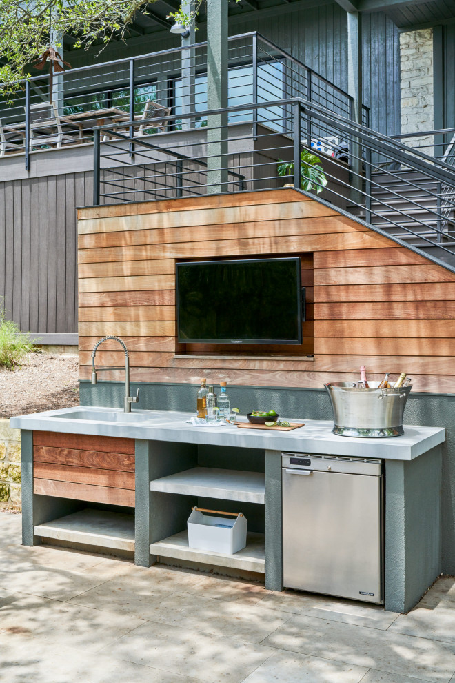 Exemple d'une terrasse arrière tendance de taille moyenne avec une cuisine d'été, des pavés en béton et aucune couverture.