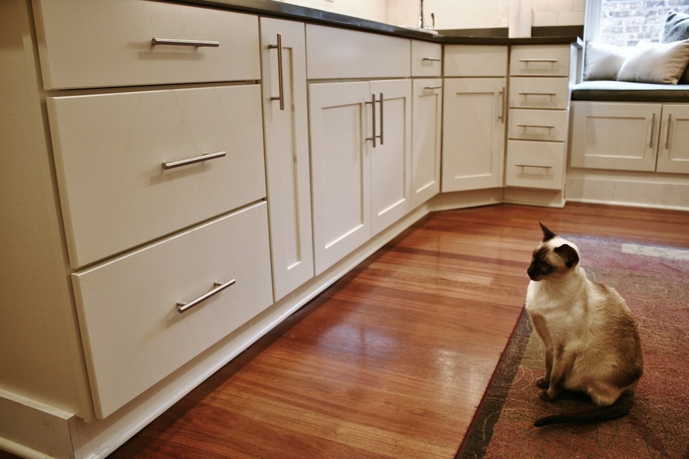 Enclosed kitchen - large transitional u-shaped light wood floor and brown floor enclosed kitchen idea in Chicago with an undermount sink, shaker cabinets, white cabinets, quartz countertops, white backsplash, subway tile backsplash, stainless steel appliances and no island