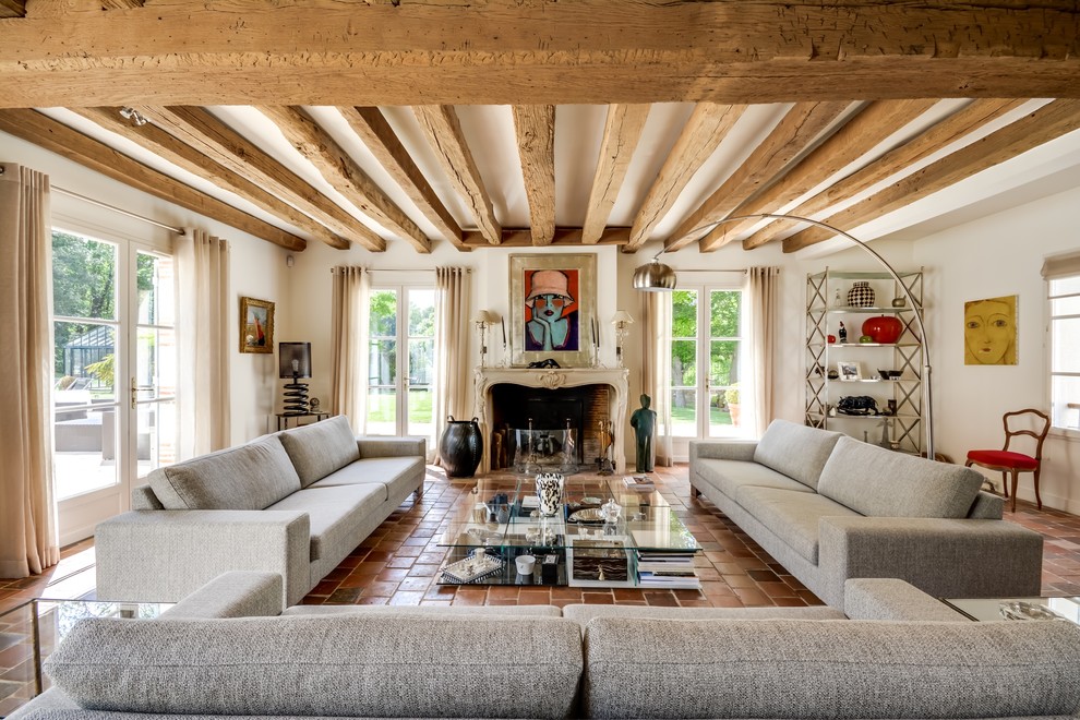 Inspiration for a large country formal enclosed living room in Paris with terra-cotta floors, white walls, a standard fireplace, a stone fireplace surround and no tv.