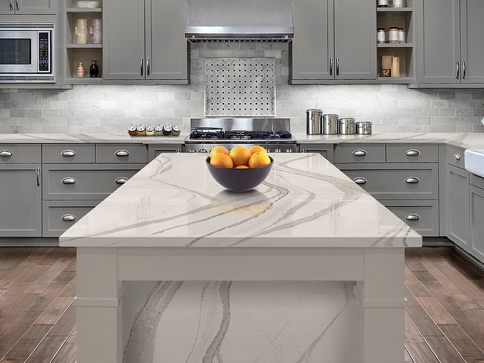 Design ideas for a mid-sized transitional l-shaped separate kitchen in Orlando with a farmhouse sink, shaker cabinets, grey cabinets, marble benchtops, beige splashback, mosaic tile splashback, stainless steel appliances, medium hardwood floors and with island.