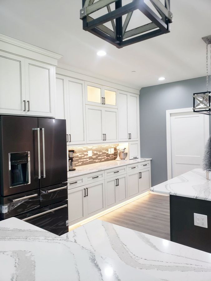 Eat-in kitchen - transitional u-shaped eat-in kitchen idea with recessed-panel cabinets, white cabinets, quartz countertops, multicolored backsplash, mosaic tile backsplash, two islands and white countertops