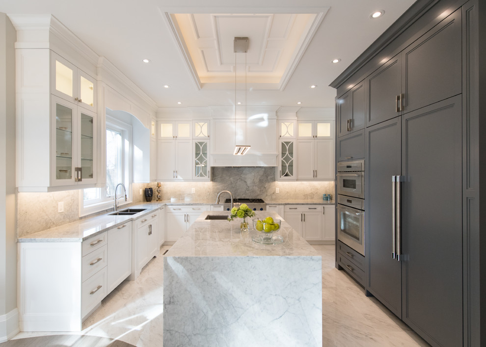 Example of a transitional u-shaped white floor kitchen design in Toronto with a double-bowl sink, recessed-panel cabinets, white cabinets, gray backsplash, stainless steel appliances, an island and gray countertops