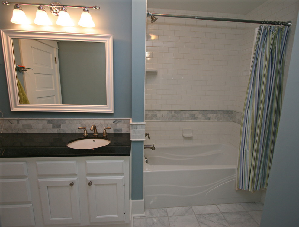 Inspiration for a small traditional kids bathroom in Seattle with an undermount sink, raised-panel cabinets, white cabinets, granite benchtops, an alcove tub, a two-piece toilet, white tile, subway tile, blue walls and marble floors.