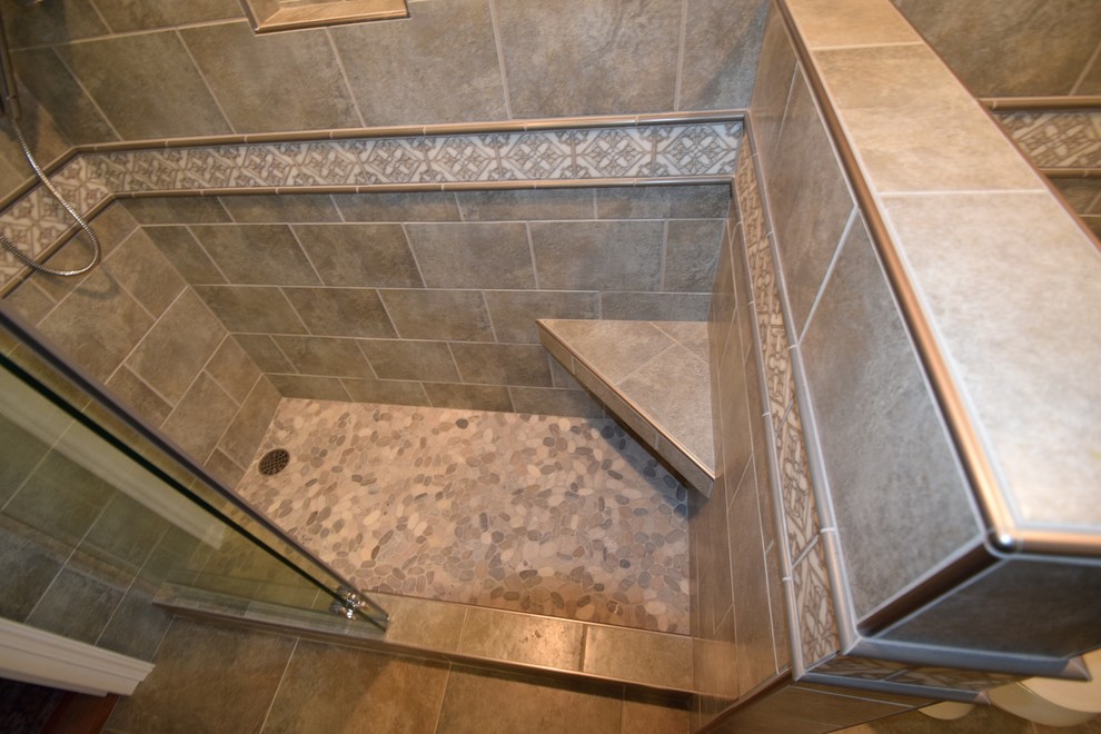 Doorless shower - small transitional master gray tile and ceramic tile ceramic tile doorless shower idea with raised-panel cabinets, white cabinets, a two-piece toilet, gray walls, a vessel sink and quartz countertops