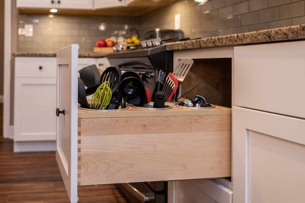 Inspiration for a mid-sized transitional galley open concept kitchen remodel with an undermount sink, shaker cabinets, white cabinets, granite countertops, green backsplash, subway tile backsplash, stainless steel appliances, an island and multicolored countertops